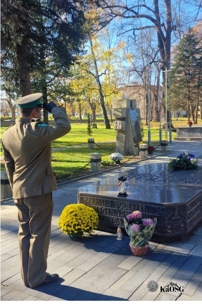 Funkcjonariusz SG w mundurze galowym oddaje honor przed grobem pierackiego w nowym saczu