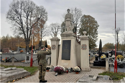 Pomnik na cmentarzu w radłowie, funkcjonariusz w mundurze moro składa honor poległym za ojczyznę
