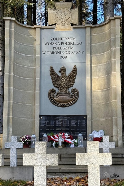 Cmentarz Poległych w Wysokiej koło Jordanowa - Pomnik bohaterskich obrońców Wysokiej, u jego stóp chryzantemy i znicze , w tym jeden z logotypem karpackiego oddziału straży granicznej