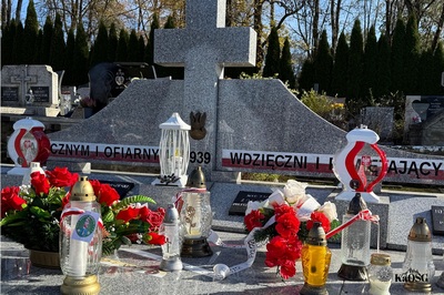 Stary Cmentarz w Rabce-Zdroju - mogiła zbiorowa poległych w czasie walk we wrześniu 1939 r. na pomniku znicze, kwiaty i biało-czerwone flagi