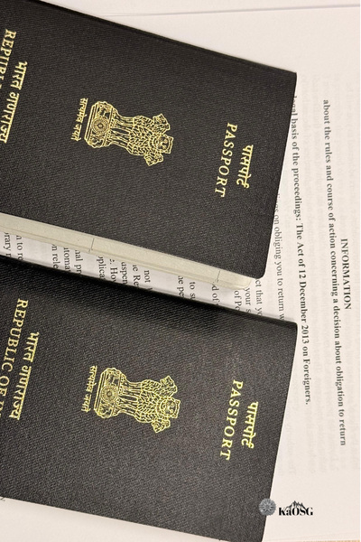 Zdjęcie ukosem leżących dwóch granatowych paszportów indyjskich