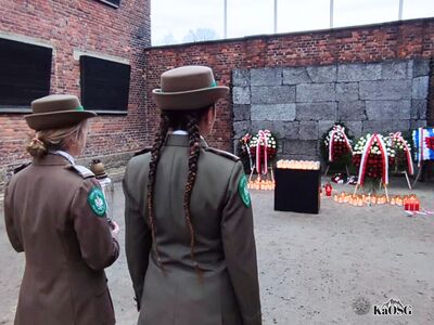 Funkcjonariuszki Grupy Zamiejscowej w Oświęcimiu PSG Kraków zapalają znicz pod Ścianą Straceń