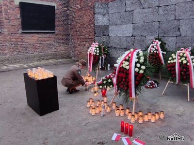 Funkcjonariuszki Grupy Zamiejscowej w Oświęcimiu PSG Kraków zapalają znicz pod Ścianą Straceń