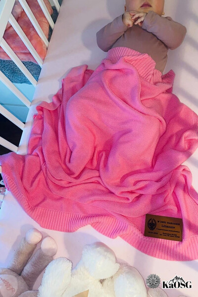 kilkumiesięczna dziewczynka przykryta różowym kocykiem, przekazanym przez komendanta kaosg