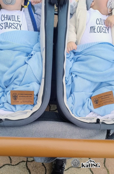 dwaj chłopcy - kilkumiesięczne bliźnięta - leżą w wózeczkach, przykryci są kocykami w kolorze niebieskim otrzymanymi od generała Jopka