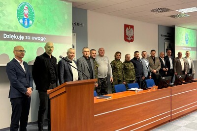 Na zdjęciu stoi grupa osób biorąca udział w konferencji