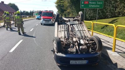 Uszkodzony samochód leży na dachu.