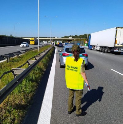 Zachowujmy czujność na drogach Funkcjonariusz SG w odblaskowej kamizelce kieruje ruchem na autostradzie