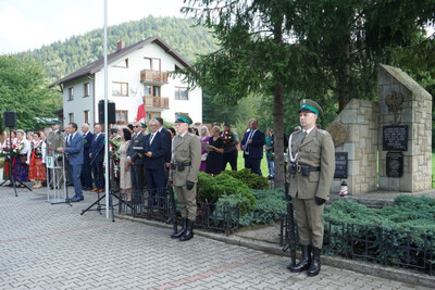 Miejsce uroczystości, plac przed pomnikiem partyzantów, Funkcjonariusze Karpackiego Oddziału Straży Granicznej wystawili posterunek honorowy, w tle uczestnicy uroczystości.