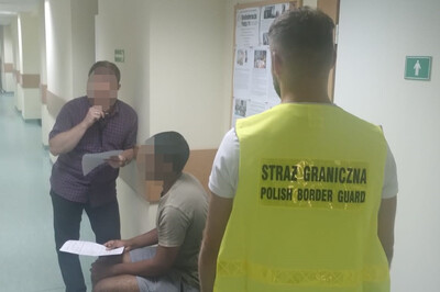 Zatrzymani w Kielcach funkcjonariusz Straży Granicznej pilnujący zatrzymanego obywatela Indii podczas przesłuchania w obecności tłumacza.