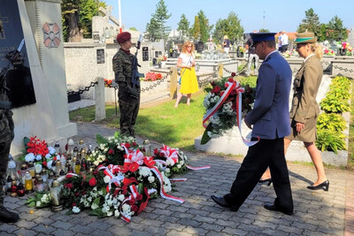 Uroczystości patriotyczne na ziemi tarnowskiej i dąbrowskiej mundurowi składający wiązankę kwiatów pod pomnikiem