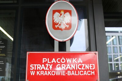 Somalijczycy – nielegalnie godło Polski, poniżej tablica z napisem Placówka Straży Granicznej w Krakowie Balicach.