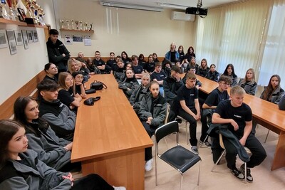 Prelekcja dla uczniów z Krosna uczniowie uczestniczący w prelekcji. siedzą przy stolikach i słuchają wykładu prowadzonego przez funkcjonariusza Straży granicznej.