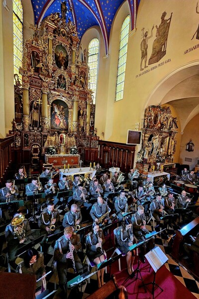 Krotoszyńska Bazylika. Około 40 funkcjonariuszy Orkiestry siedzi na krzesłach i gra na instrumentach.