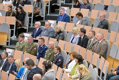 fot. ans-nt.edu.pl zebrani goście na sali w której następuje inauguracja roku akademickiego. widok na przedstawicieli służb mundurowych.