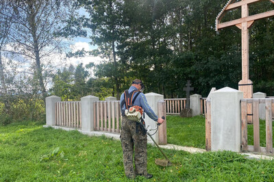 VIII akcja sprzątania cmentarzy z okresu I wojny światowej funkcjonariusz straży granicznej koszący trawę na cmentarzu wojennym
