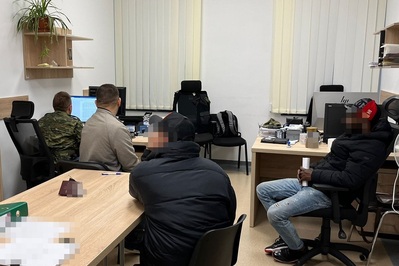 Kolumbijczycy przebywali nielegalnie w Polsce dwóch cudzoziemców siedzących w pomieszczeniu służbowym Straży Granicznej podczas wykonywanych wobec nich czynnościach służbowych. przy komputerze znajduje się funkcjonariusz straży granicznej.