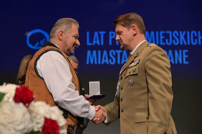 Burmistrz Zakopanego w stroju regionalnym wręcza medal i gratuluje Komendantowi Placówki SG w Zakopanem.