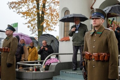 Cmentarz w Wierzchosławicach. Przed grobowcem Wincentego Witosa stoją funkcjonariusze SG pełniący wartę honorową. W tle pod parasolami uczestnicy uroczystości.