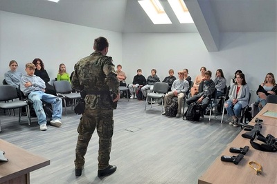 Przygotowanie strzeleckie młodzieży w Tarnowie Funkcjonariusz SG prowadzący zajęcia z przygotowania strzeleckiego w towarzystwie młodzieży
