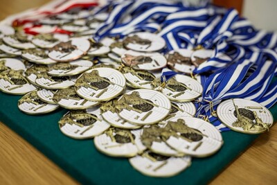 Na stole leży bardzo dużo medali pamiątkowych, przeznaczonych dla wszystkich uczestników mistrzostw strzeleckich.