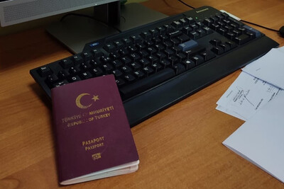 Na biurku przy klawiaturze komputera lezy paszport obywatela Turcji. Obok dokument wypełnione przez funkcjonariuszy Straży Granicznej w  Kielcach