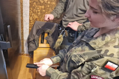 Funkcjonariusze KaOSG szkolili młodzież z klas mundurowych Uczennica z klasy mundurowej trzymająca w dłoni krótką broń palną.