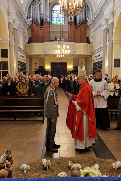Komendant KaOSG wyróżniony przez Biskupa Polowego Komendant Karpackiego Oddziału Straży Granicznej ma wręczane odznaczenie z rąk Biskupa Polowego. uroczystość odbywa się w kościele.