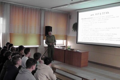 Rozmawiali o Straży Granicznej funkcjonariusz straży granicznej podczas spotkania z uczniami. prowadzi prelekcje.