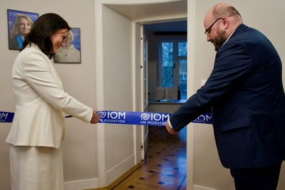 fot. IOM szefowa Misji IOM Polska wraz z przedstawicielem urzędu miasta Kraków przecinający szarfę nowo otwartego biura IOM.