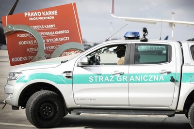 Kolaż zdjęć. W tle płyta lotniska i stojący na niej samochód służbowy Straży Granicznej. W nim siedzi zamaskowany funkcjonariusz SG. Na drugim zdjęciu Kodeks Karny i położone na nim kajdanki.