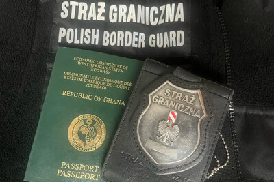 na polarze służbowym straży granicznej leży odznaka funkcjonariusza sg obok niej paszport obywatela Ghany