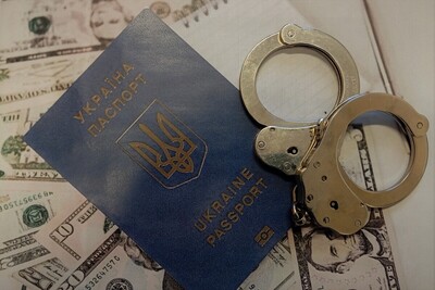 Na rozłożonych dolarach leży paszport obywatelki Ukrainy i kajdanki