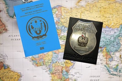 Na mapie świata (część z kontynentem europejskim i afryką) leży paszport zatrzymanej obywatelki Rwandy oraz odznaka funkcjonariusza SG
