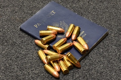 Na wykładzinie leży paszport obywatela USA, a na nim rozrzucone jest 18 sztuk ostrej amunicji, która została ujawniona przez funkcjonariuszy SG na Balicach.