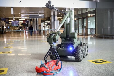 Hala odlotów lotniska w krakowie - balicach. Robot pirotechniczny sprawdza zawartość plecaka, który został pozostawiony bez opieki.