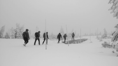 Szkolenie "kondycyjno-taktyczne" funkcjonariuszy KaOSG funkcjonariusze straży granicznej podczas szkolenia idą pieszo szlakiem górskim. trasa biegnie w warunkach trudnych przy obfitych opadach śniegu oraz porywistym wietrze.