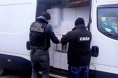 funkcjonariusz straży granicznej oraz funkcjonariusz CBŚP sprawdzający towar na busie który został zatrzymany podczas akcji.