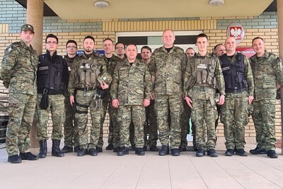 Komendant Karpackiego oddziału straży Granicznej wraz z kadrą kierowniczą i funkcjonariuszami straży granicznej oddelegowanymi do wsparcia działań na granicy z Białorusią. wszyscy pozują do wspólnego zdjęcia przed wejściem do jednej z placówek SG.