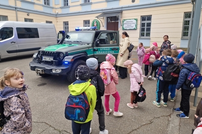 dzieci obserwują pojazd służbowy straży granicznej.