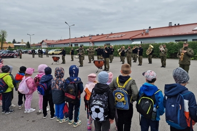 dzieci oglądające pokaz musztry paradnej w wykonaniu orkiestry reprezentacyjnej straży granicznej.