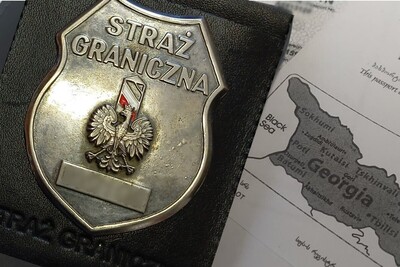 Na kopii paszportu obywatela Gruzji leży odznaka straży granicznej