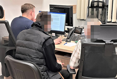 pomieszczenia służbowe tarnowskiej placówki sg. dwóch obywateli mołdawii siedzi przy biurku i jest przesłuchiwanych przez funkcjonariusza sg
