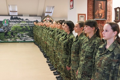 funkcjonariusze straży granicznej stoją w szeregu podczas uroczystej zbiórki z okazji awansowania ich na pierwszy stopień w korpusie podoficerów. są w mundurach typu polo.