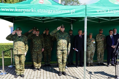 Komendant karpackiego oddziału straży granicznej wraz zaproszonymi gośćmi oddaje honor podczas odgrywanego hymnu.