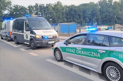 Na jezdni stoją radiowozy straży granicznej, inspekcji transportu drogowego oraz policji, podczas akcji w której kontrolowani są taksówkarze