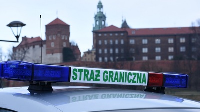 widoczny napis straż graniczna na pojeździe służbowym straży granicznej. w tle widoczny zamek królewski na Wawelu.