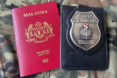 na materiale moro leży paszport obywatela malezji i odznaka sg