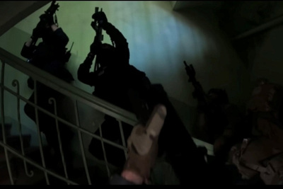 Funkcjonariusze uzbrojeni w długą broń wchodzą po schodach. Broń uniesiona jest do góry, gdyż ćwiczą scenariusz dotyczący poszukiwania przestępców w pomieszczeniach.