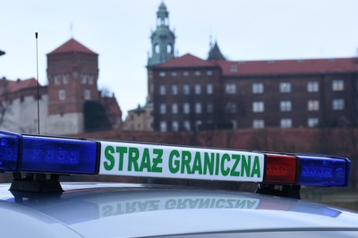 napis straż graniczna znajdujący się na sygnale świetlno-dźwiękowym pojazdu służbowego straży granicznej, umieszczony na dachu pojazdu. w tle widoczny zamek Królewski na Wawelu.